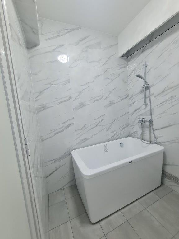 Bathroom with freestanding tub and marble tiles